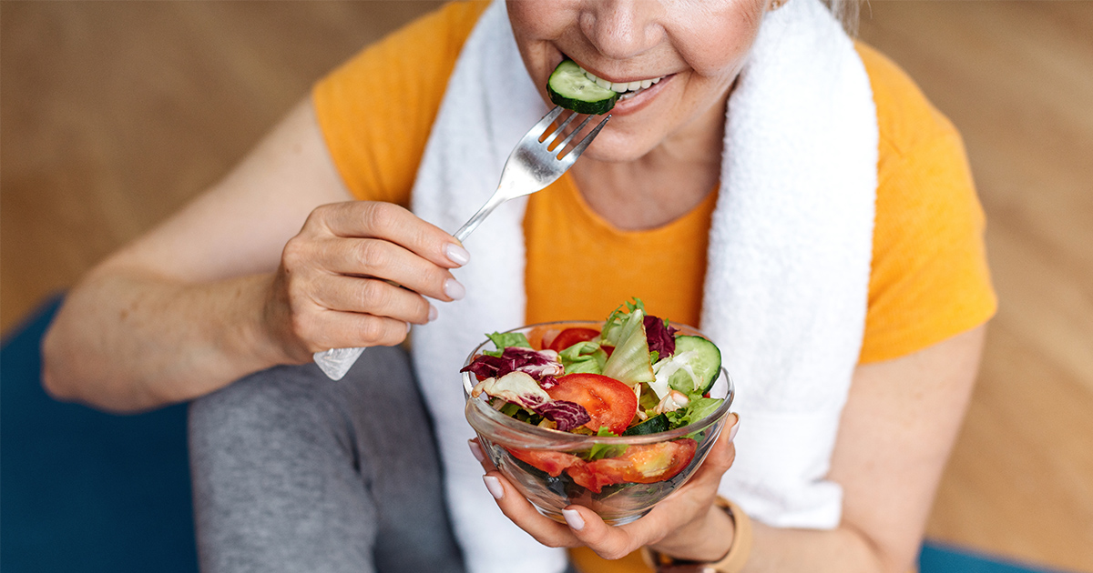 kvinna som äter sallad efter träningspass för att stärka bentäthet