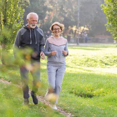 Äldre par joggar på en stig